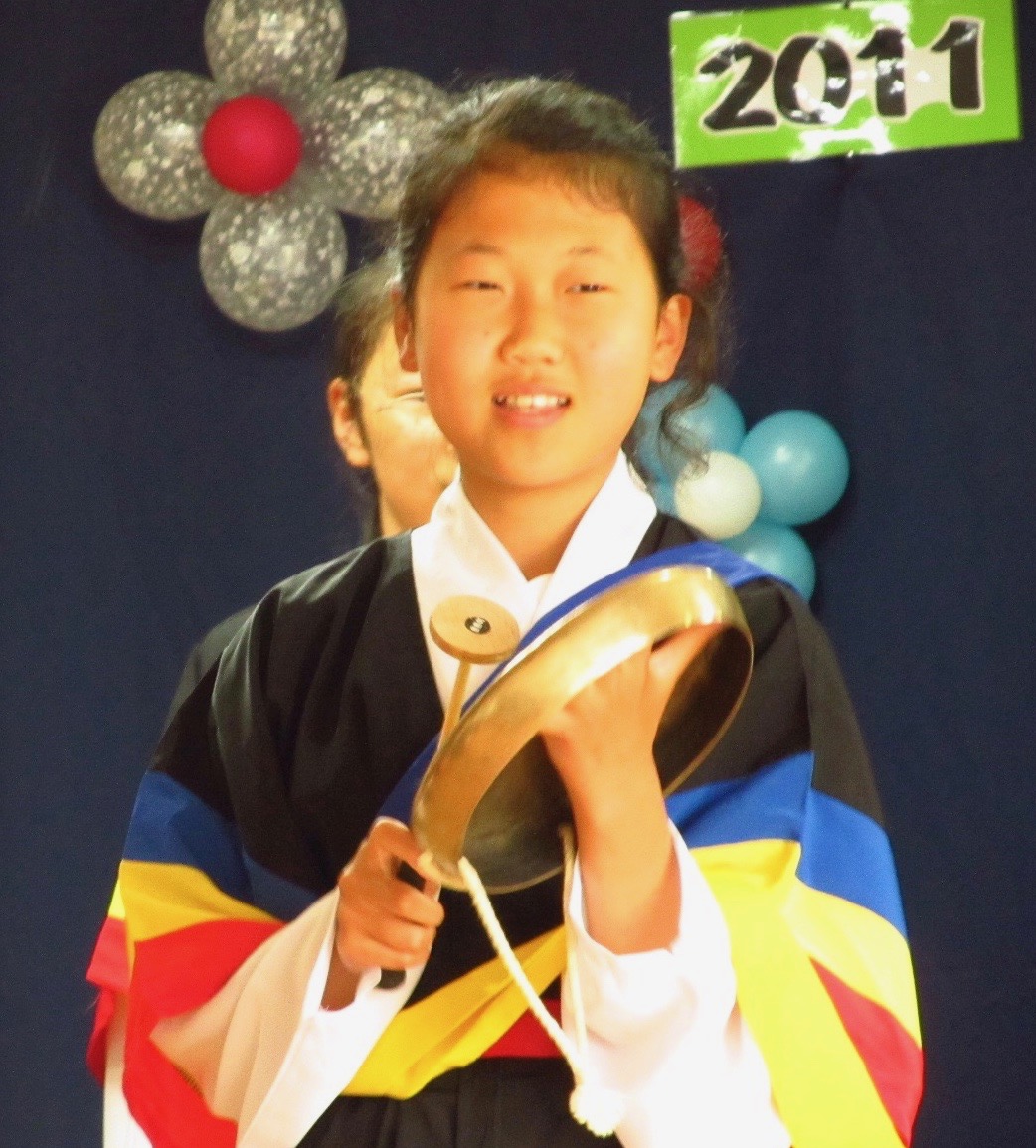 elementary school student playing traditional Korean percussion instrument